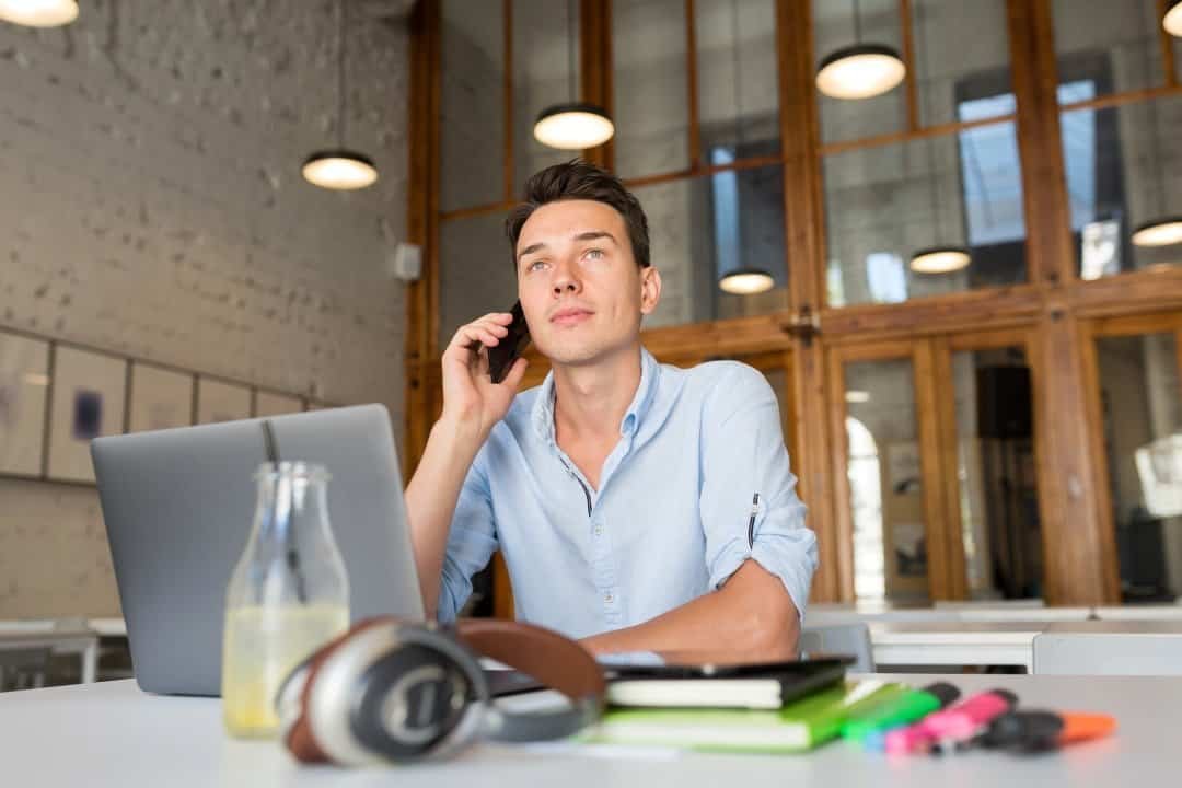 emprendedor con laptop hablando por telefono