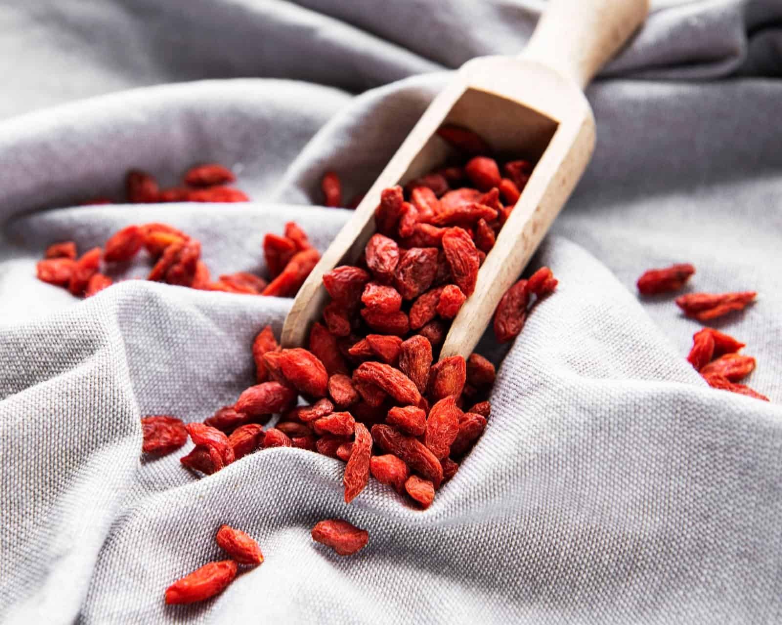 Puñado de bayas de Goji sobre tela gris