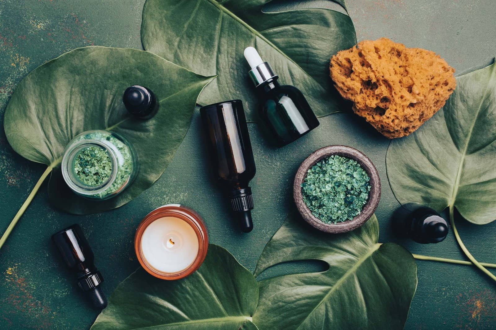 Fondo verde con frascos de cosméticos maquilados